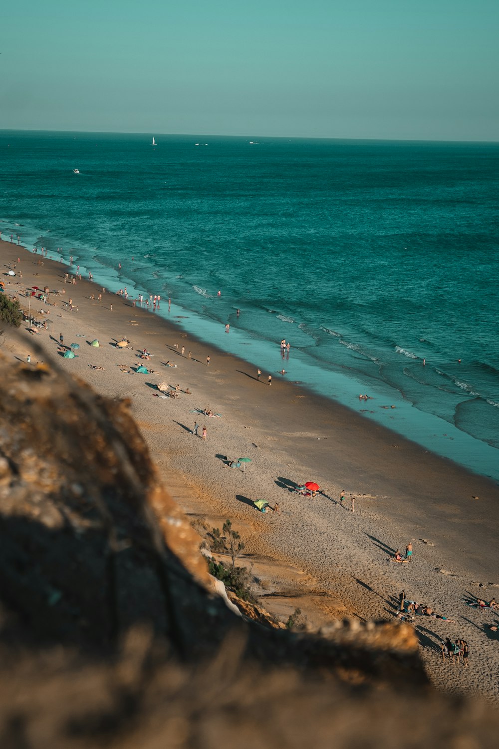 um grupo de pessoas em pé em cima de uma praia de areia