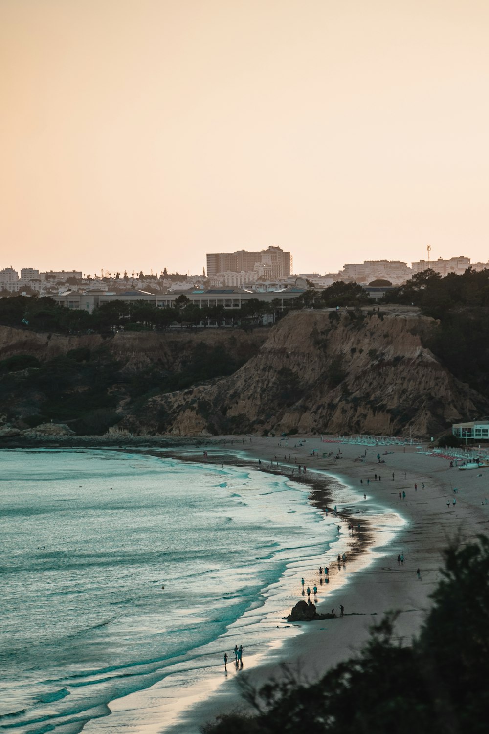 a view of a beach with people walking on it