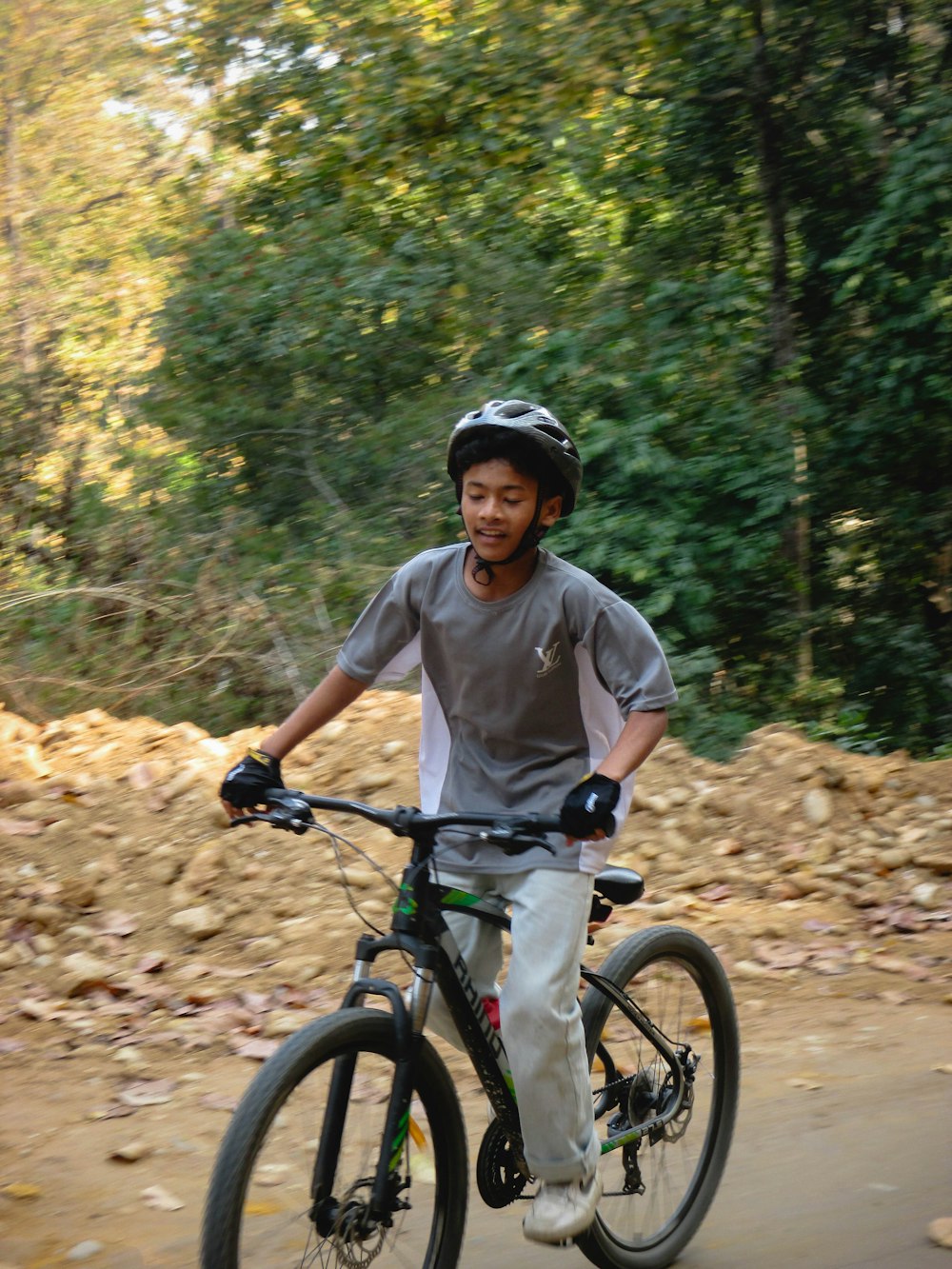 a man riding a bike down a dirt road