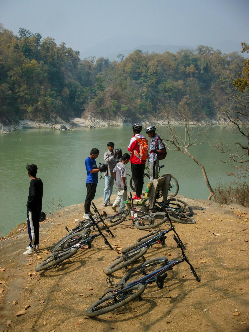 Un grupo de personas de pie alrededor de una pila de bicicletas