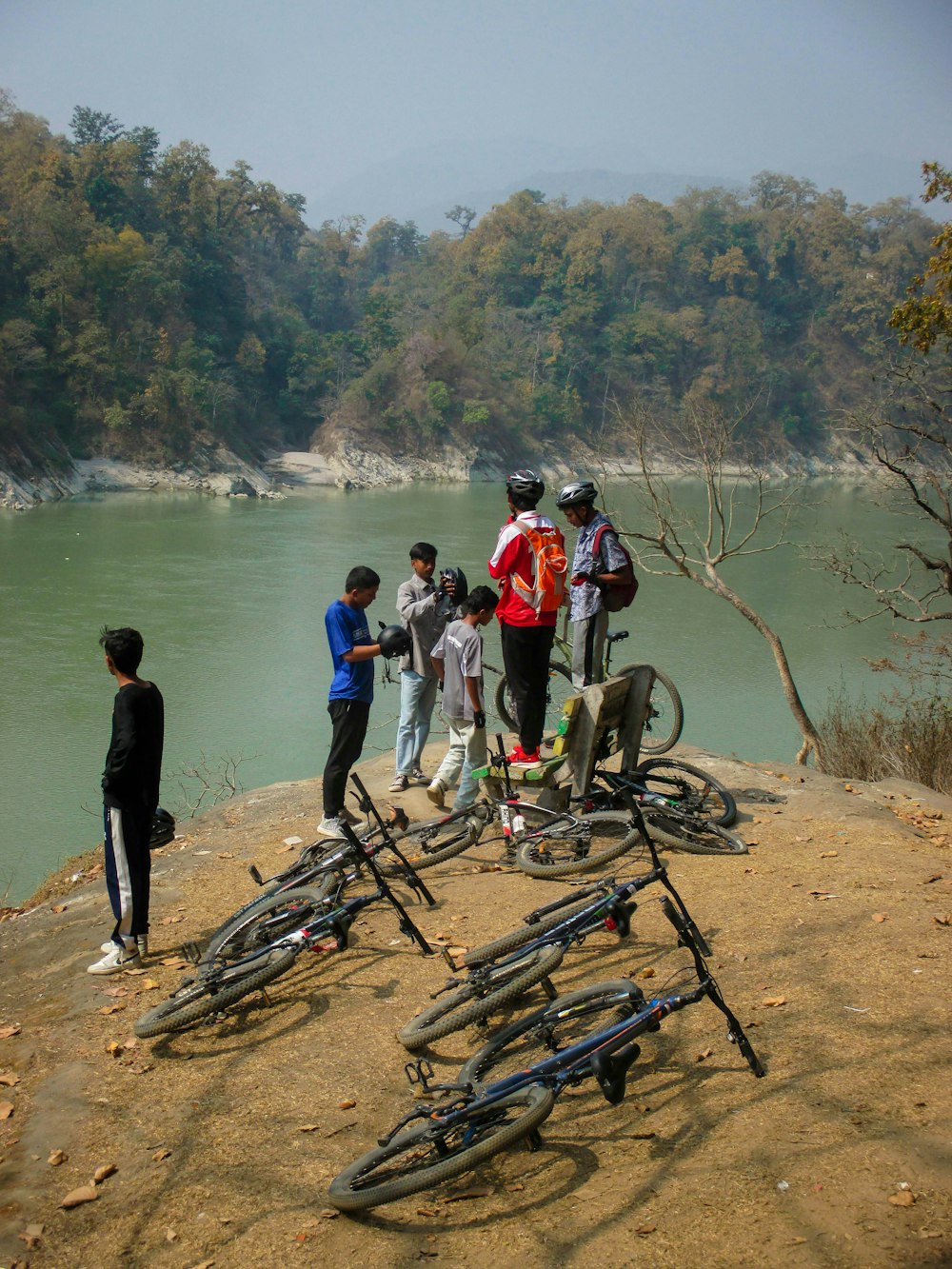 a group of people standing around a pile of bikes