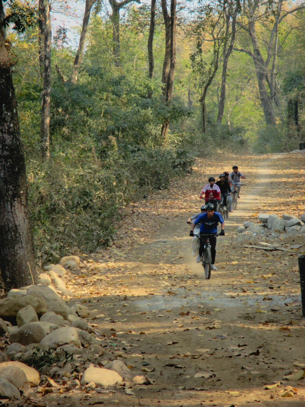 a group of people riding motorcycles down a dirt road