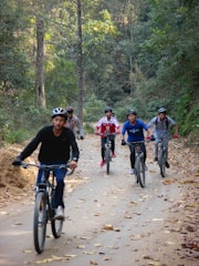 a group of people riding bikes down a dirt road
