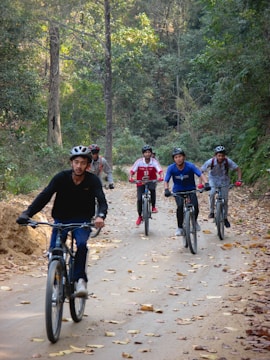 a group of people riding bikes down a dirt road