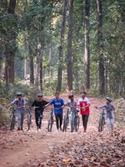 a group of people riding bikes down a dirt road