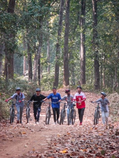 a group of people riding bikes down a dirt road