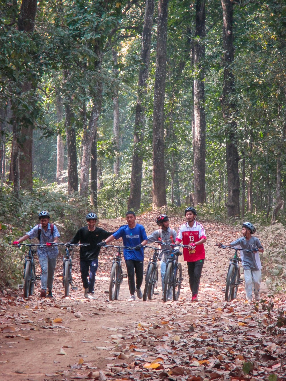 a group of people riding bikes down a dirt road