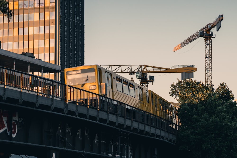 a train on a track with a crane in the background