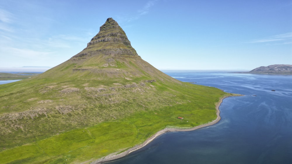 an aerial view of a mountain with a body of water in front of it