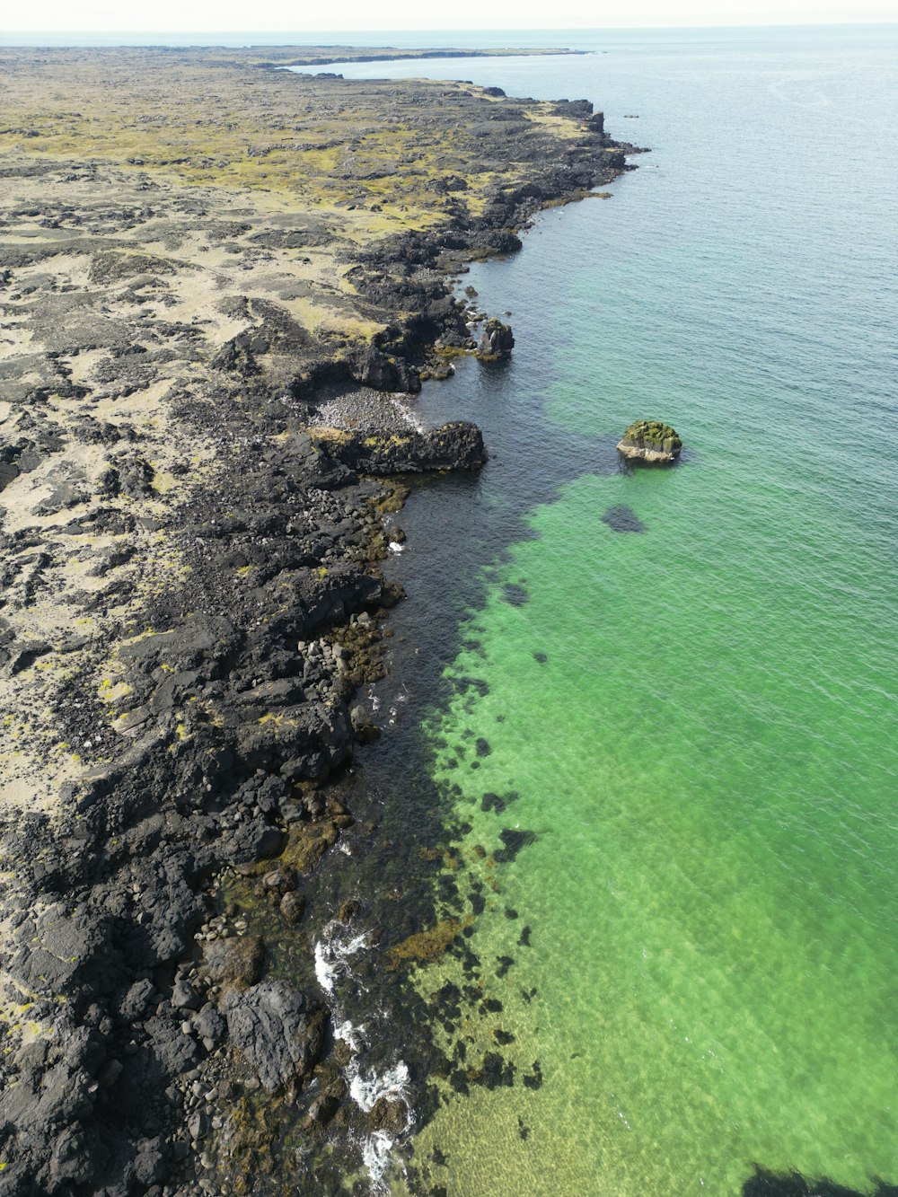 uma vista aérea de um corpo de água com uma pequena ilha no meio de
