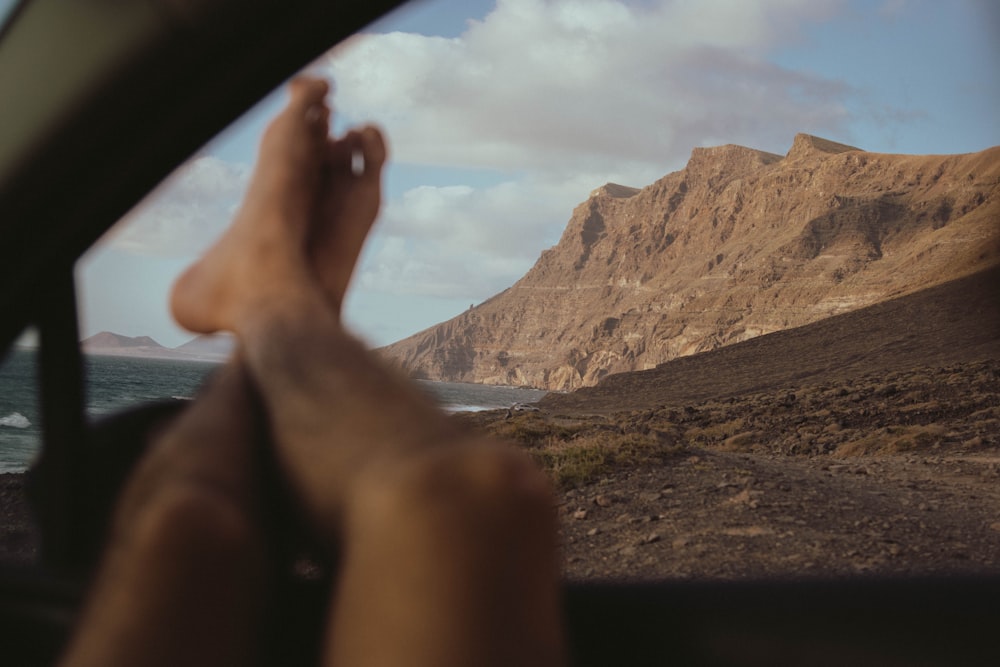 a person's feet sticking out of a car window