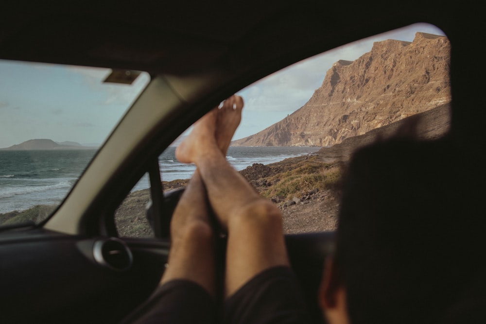 a person's feet sticking out of a car window