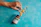 Close-up of a child reaching for a Verdanido supplement bottle on a kitchen counter with green accents.