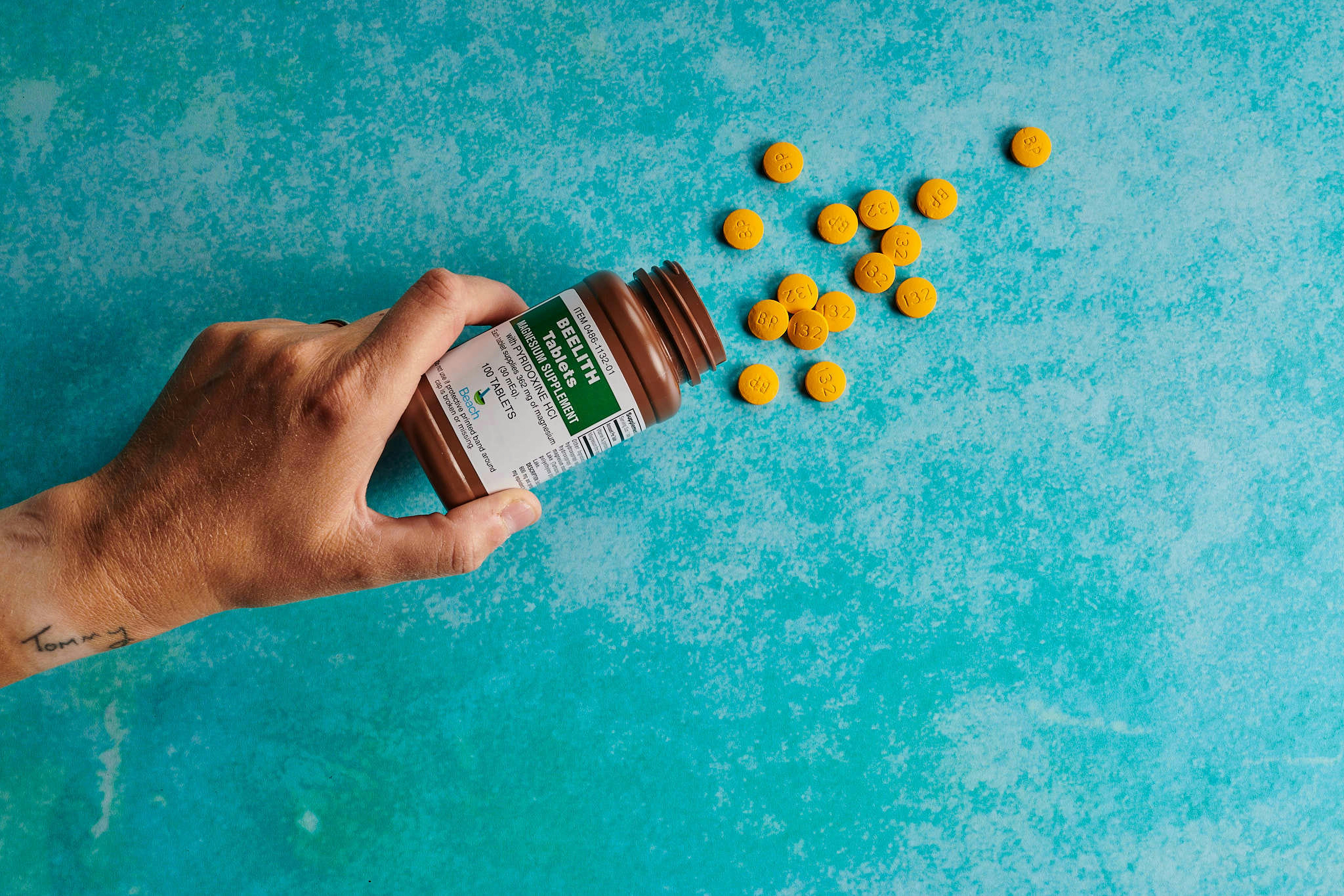 Pouring pills on blue background