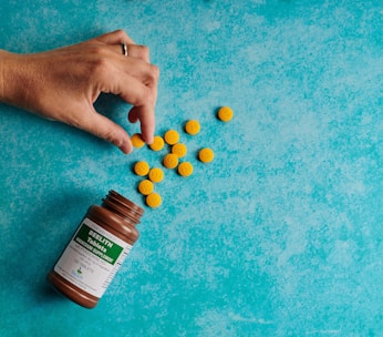 Close-up of a hand picking up a prescription medicine box from a pharmacy shelf.
