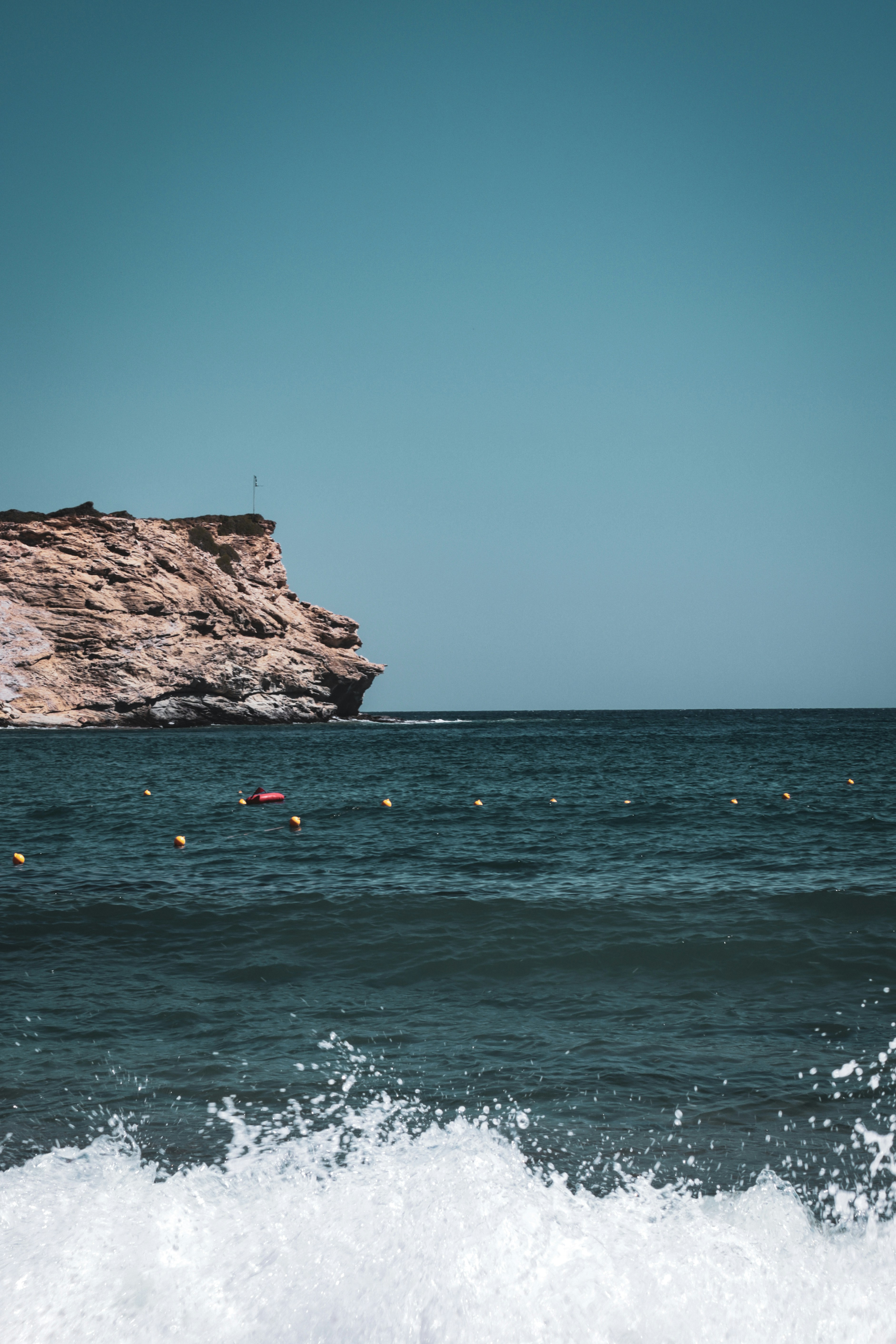 a large body of water with a cliff in the background