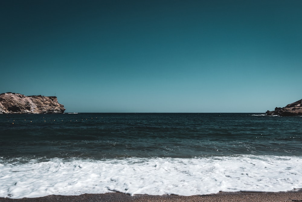 a person standing on a beach next to the ocean