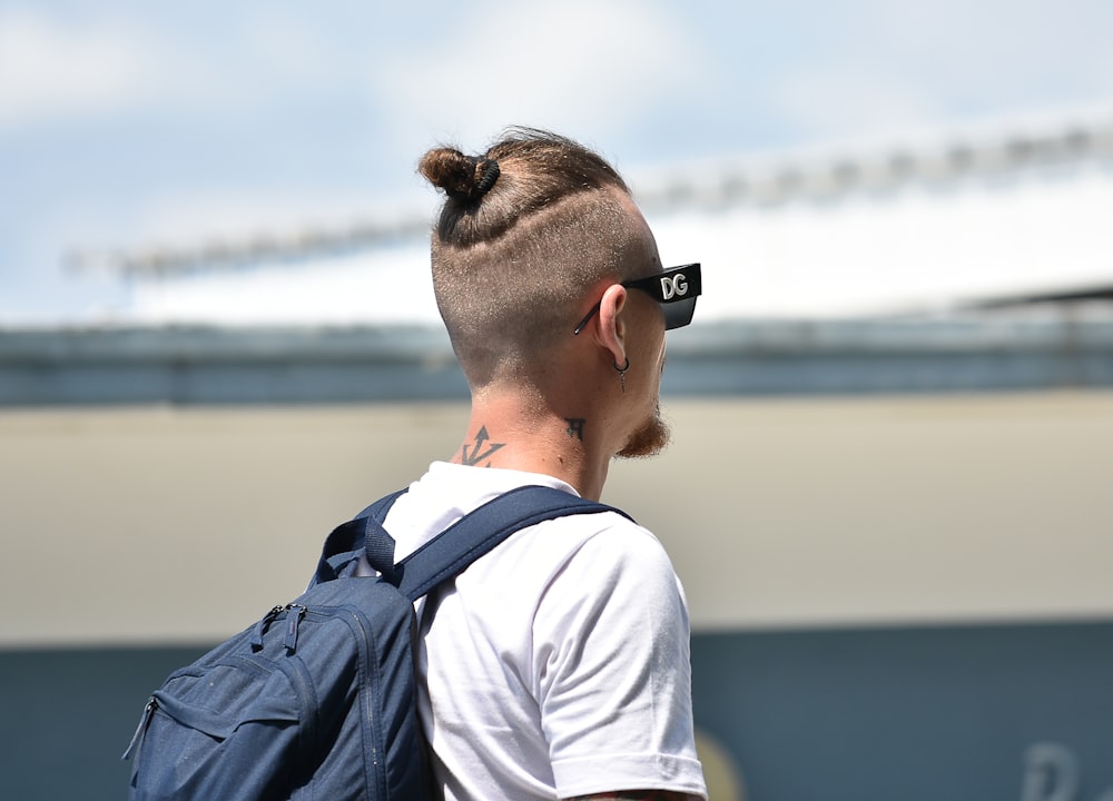 a man with a mohawk undercut wearing a back pack