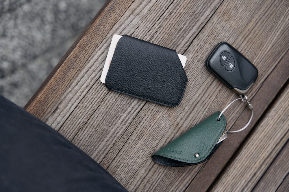 a cell phone, wallet, and keychain sitting on a table