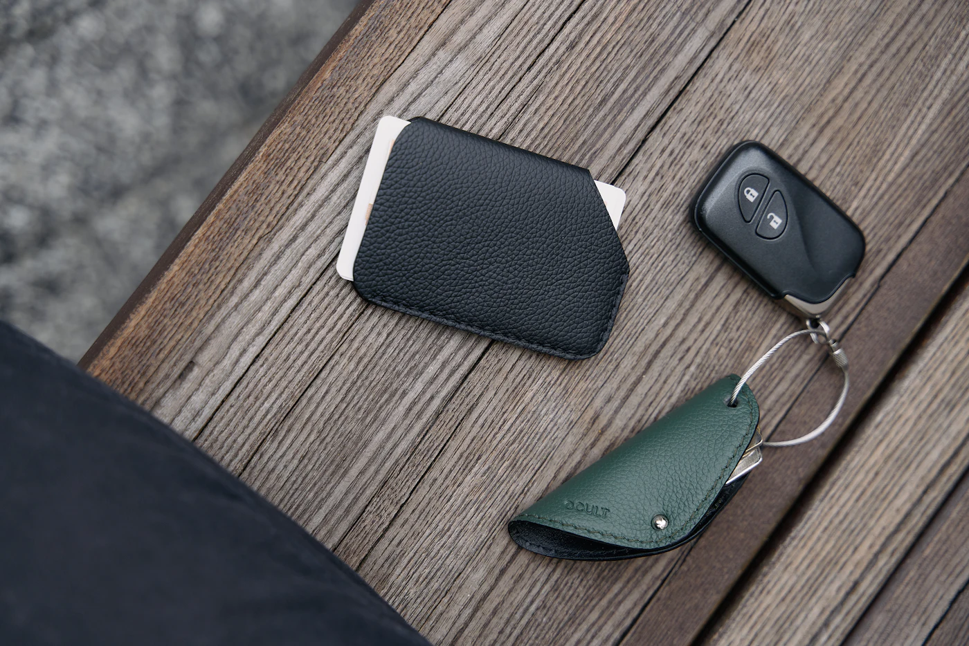 A phone, minimal wallet and keychain on a table