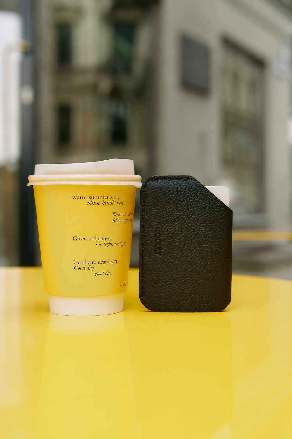 a cup of coffee sitting on top of a yellow table