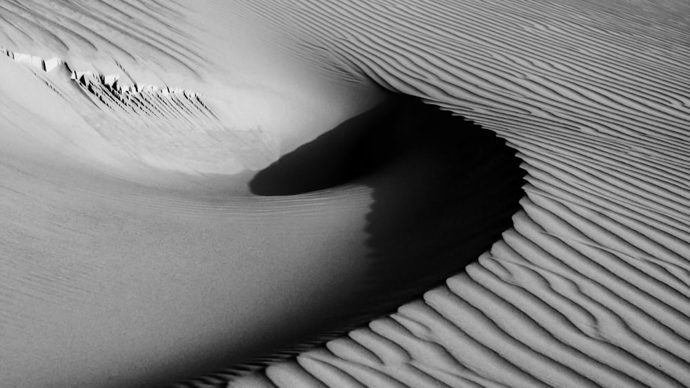 a black and white photo of a sand dune