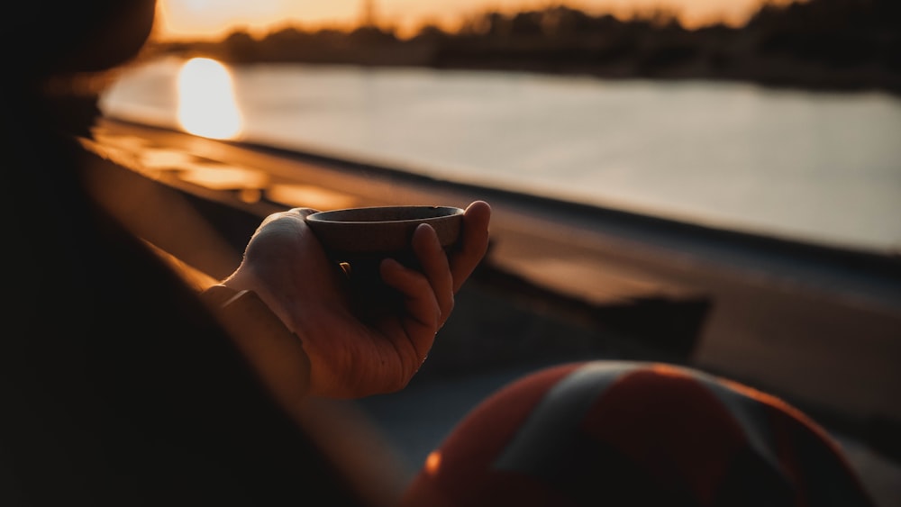 a person holding a cup of coffee in their hand