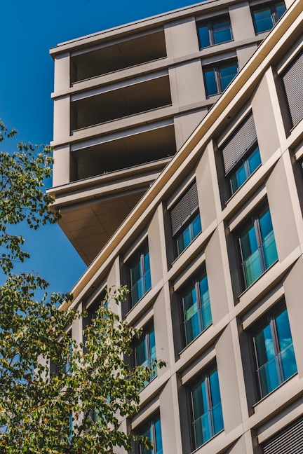 a tall building with lots of windows next to a tree