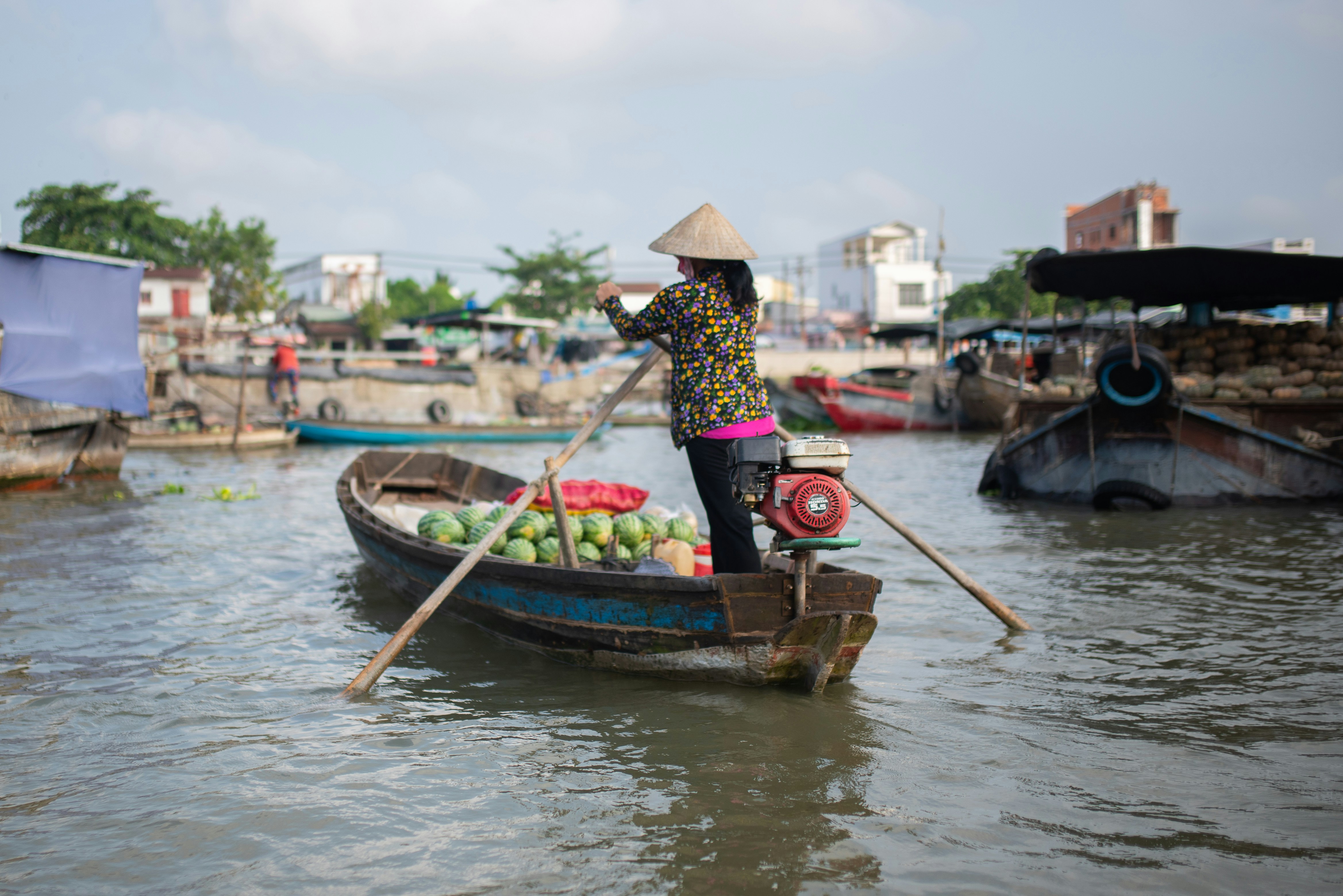 a woman in a boat filled with watermelons
