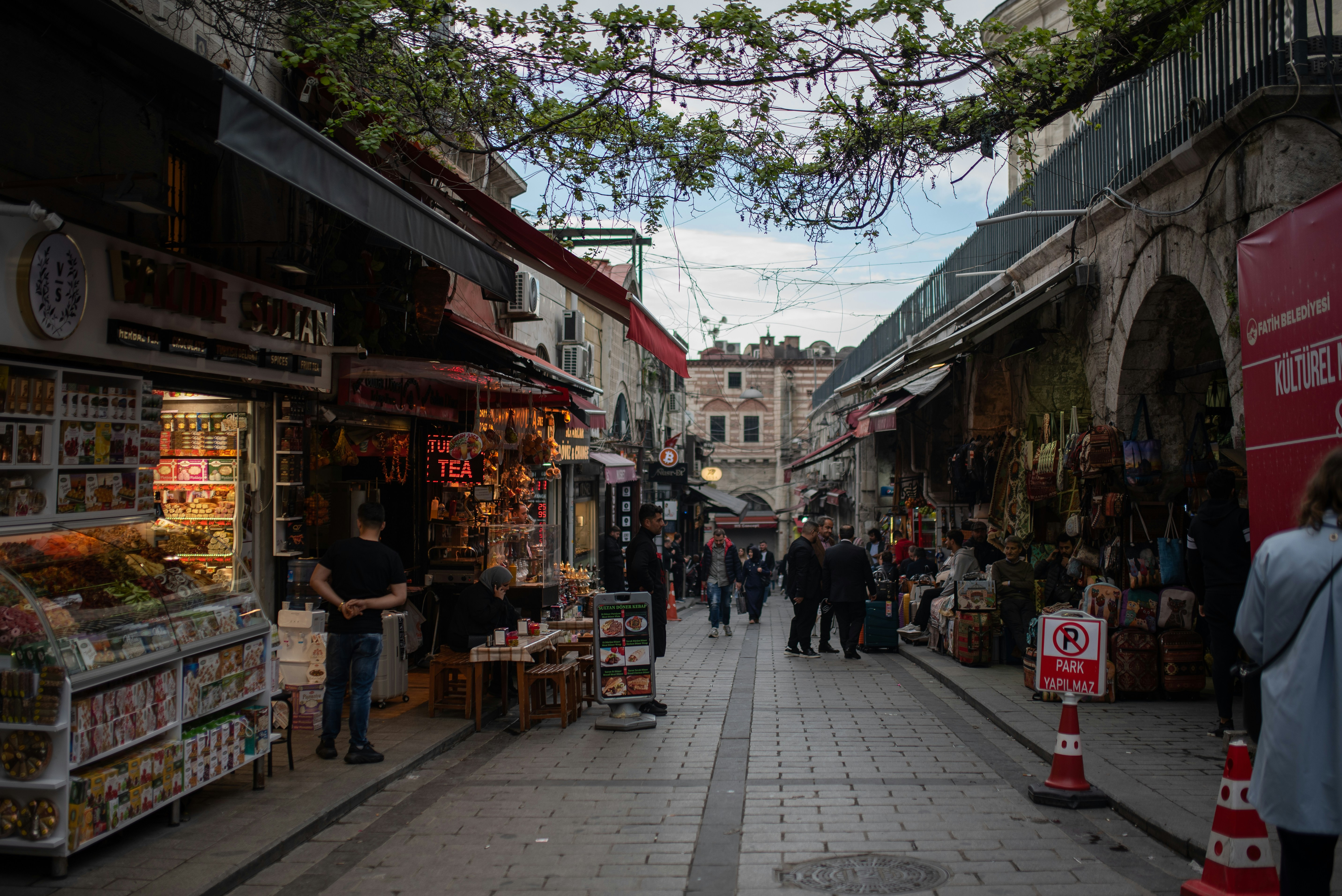 a group of people walking down a street next to shops
