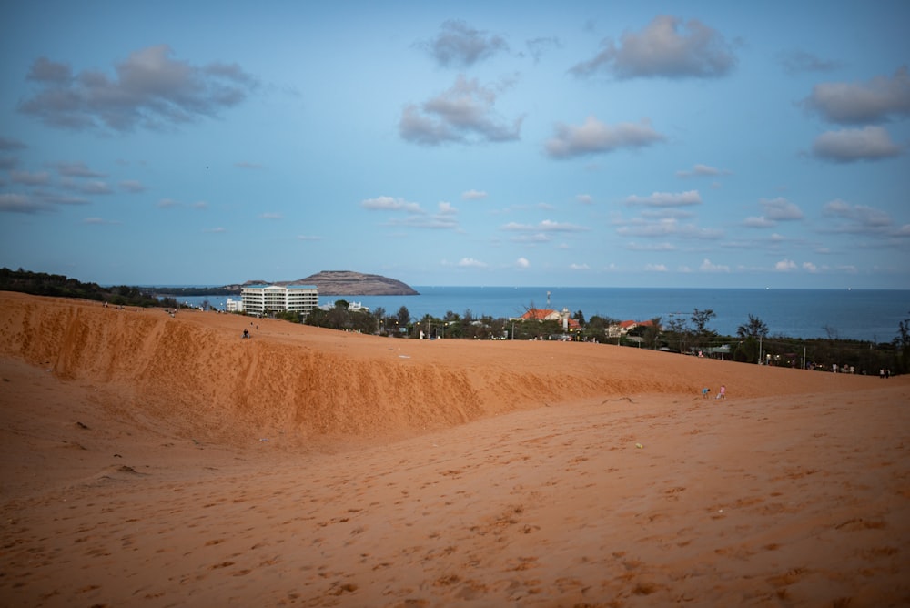 a sandy beach with a building in the distance