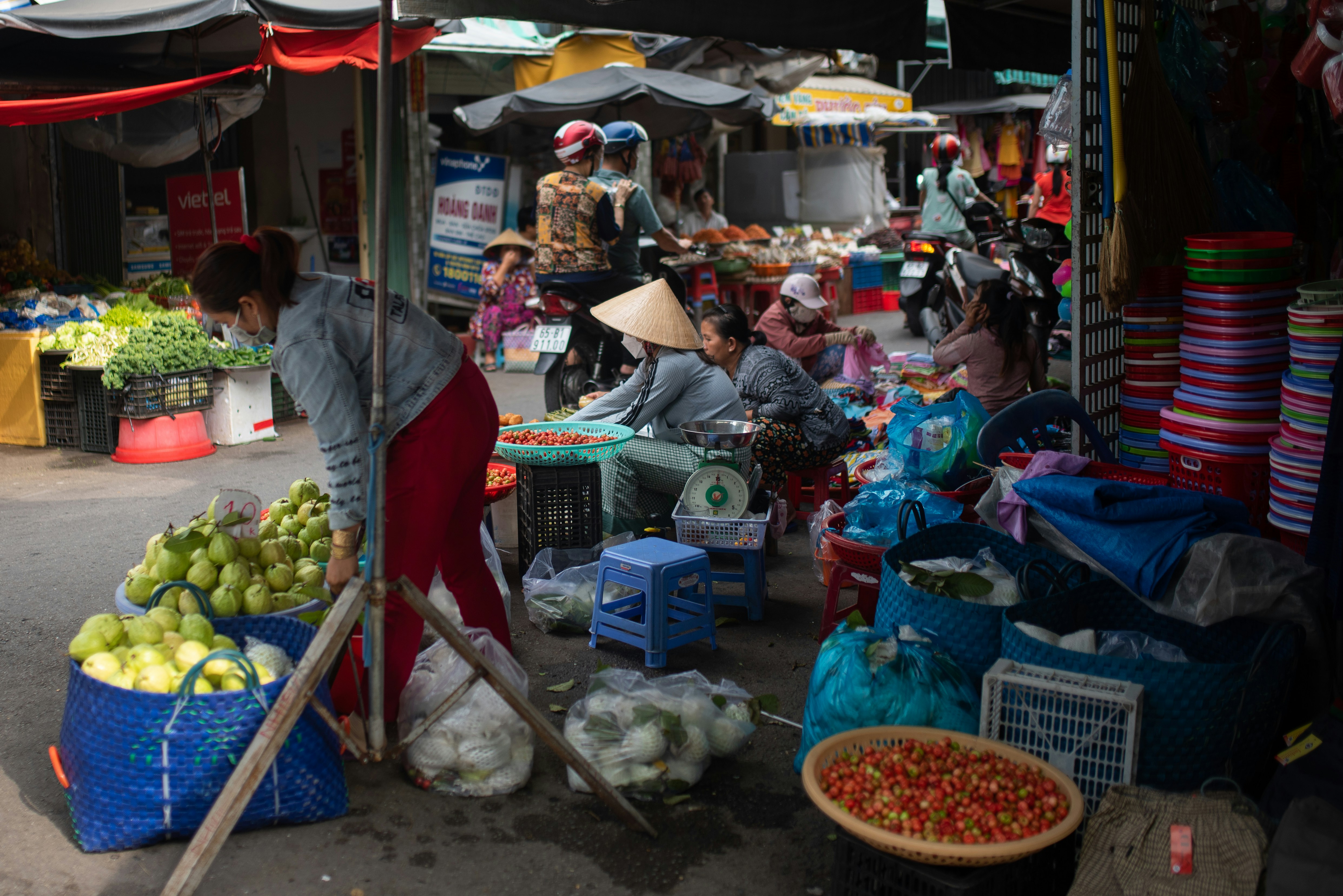Busy outdoor Caribbean market with vendors selling fresh tropical fruits and hand-crafted local goods