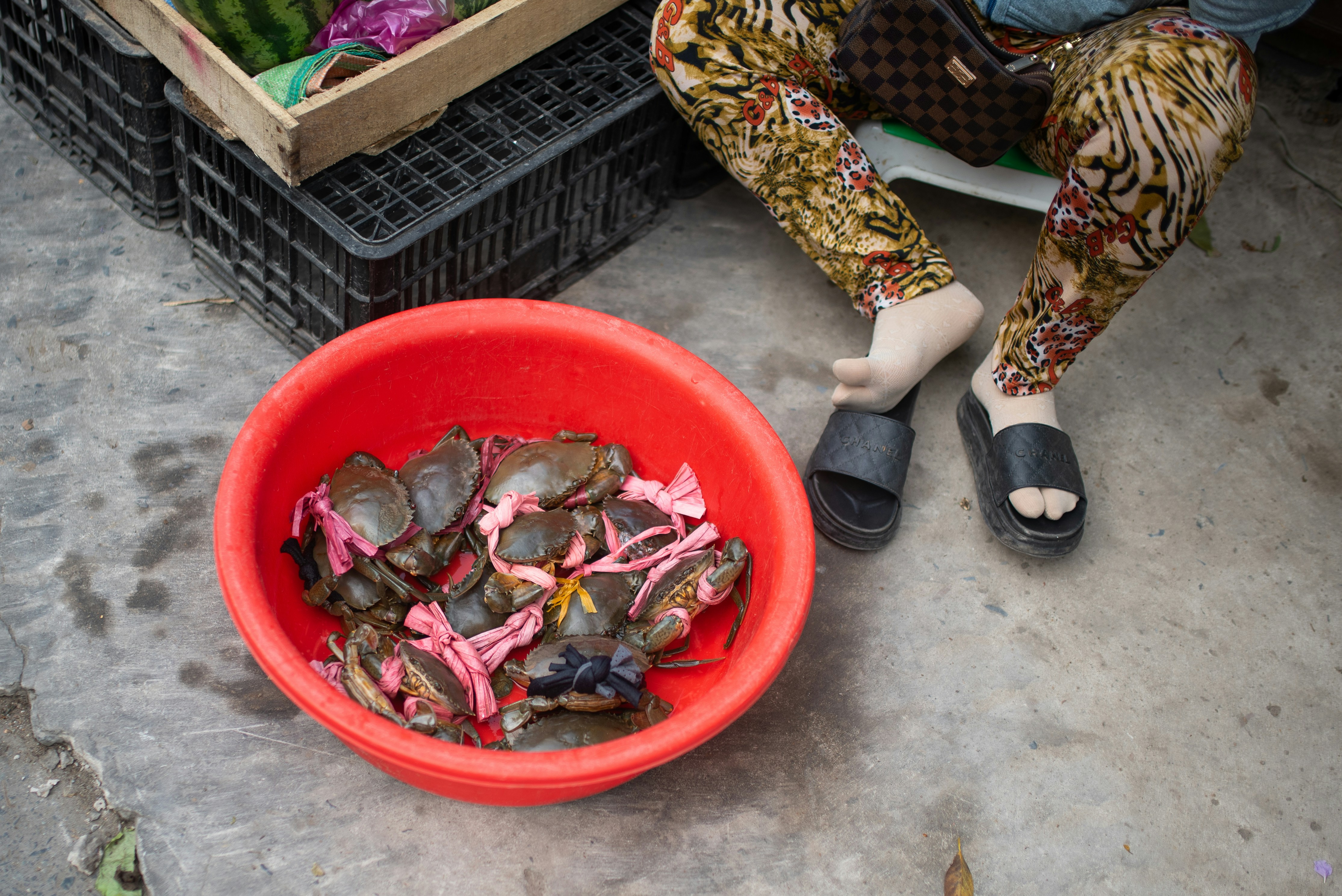 a woman sitting on the ground next to a bowl of food