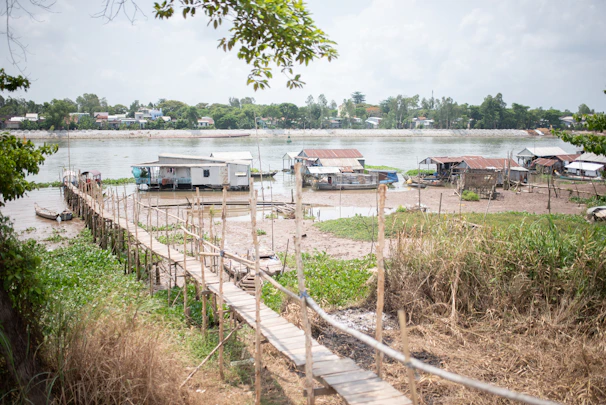 A peaceful village scene with Tucuju people gathered near wooden houses by the river.