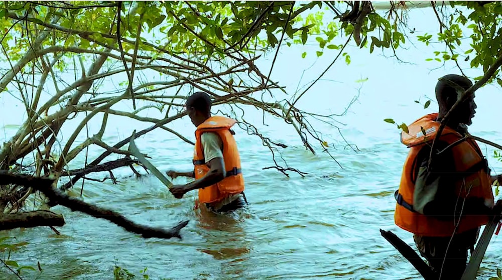 two people in life jackets wading through a body of water