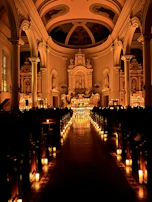 A candlelit evening service inside Bramham Sanctum, highlighting the warm glow against ancient walls.