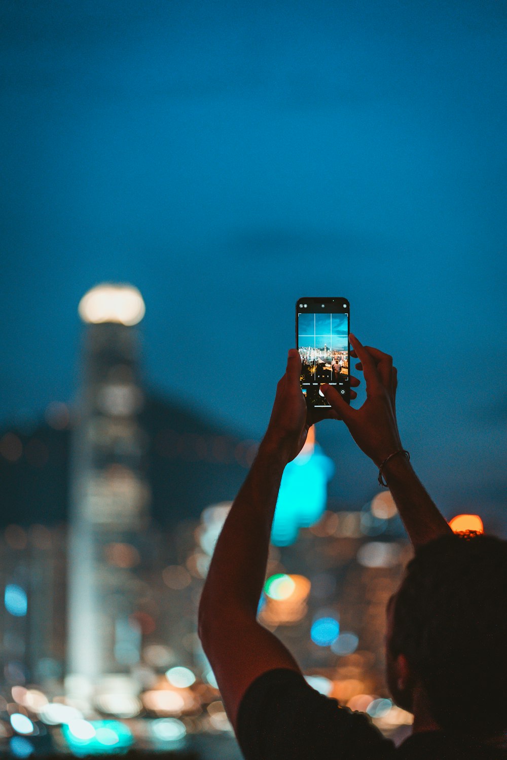 a person taking a picture of a city at night