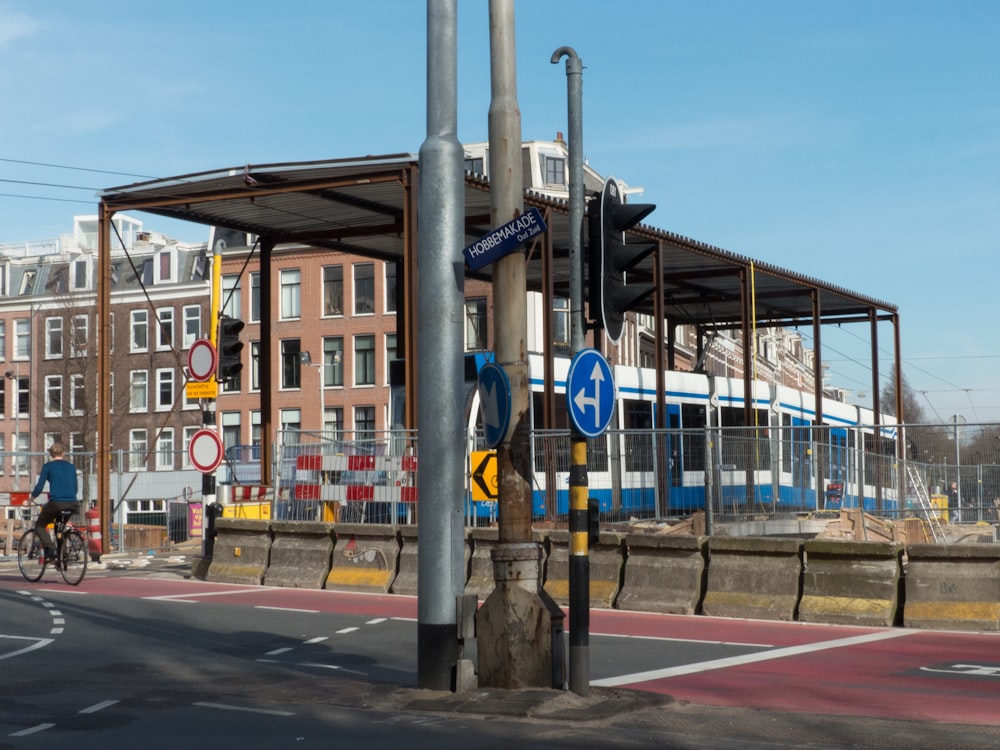 a blue and white train traveling past a tall building