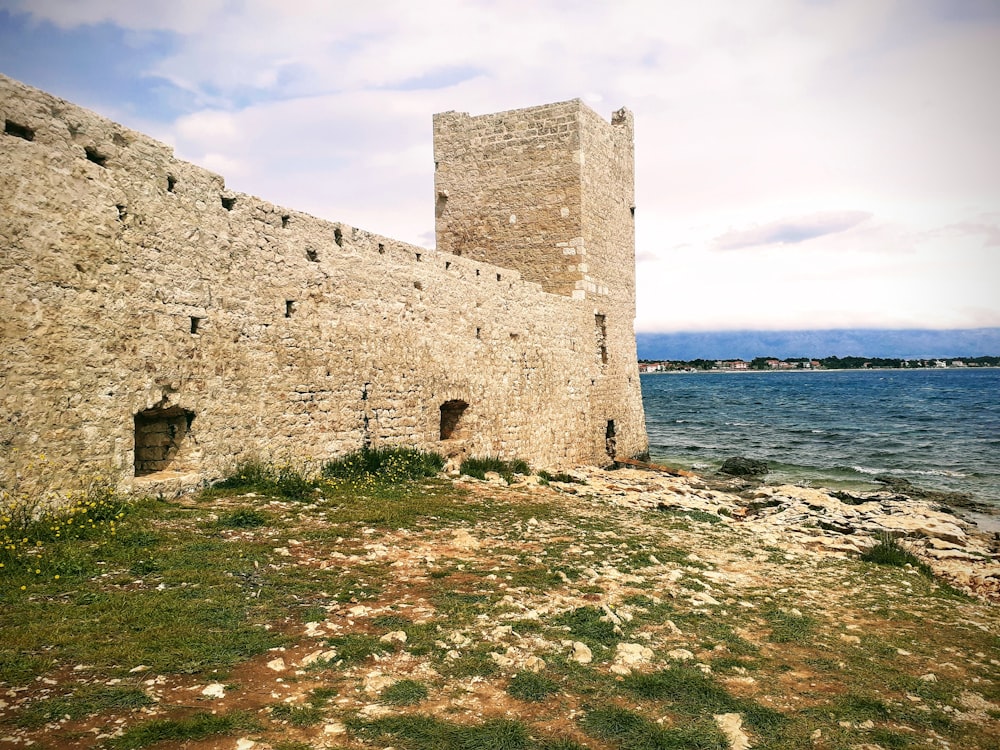 a stone castle sitting next to a body of water