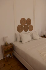 a bed with white sheets and pillows in a room
