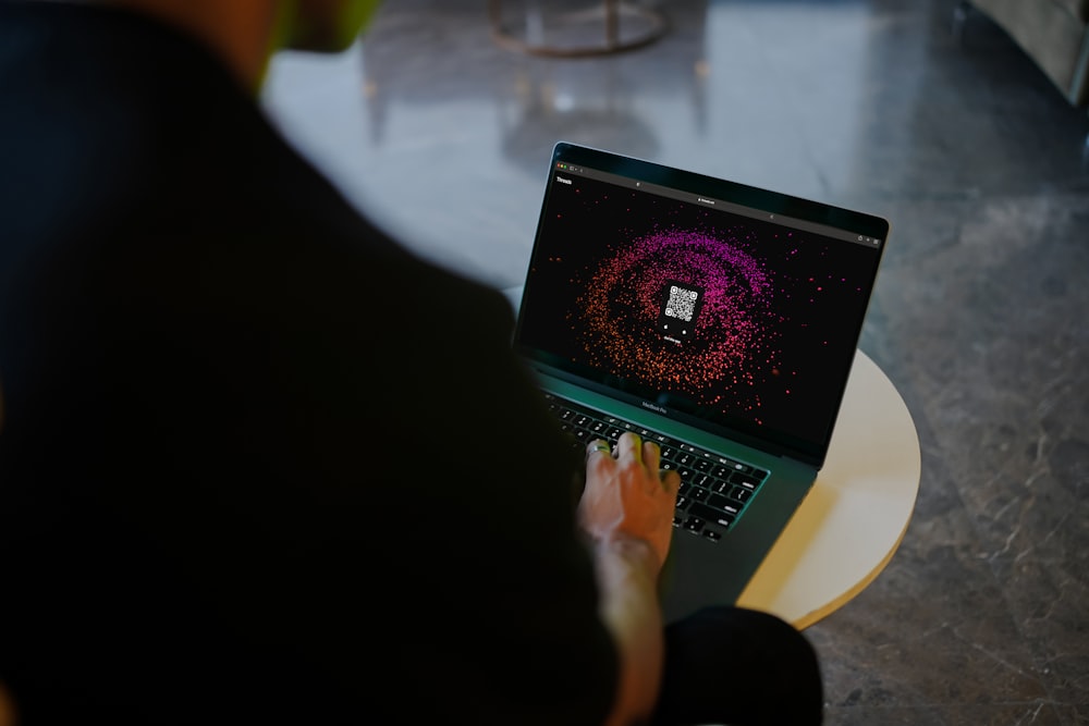 a person sitting in front of a laptop computer