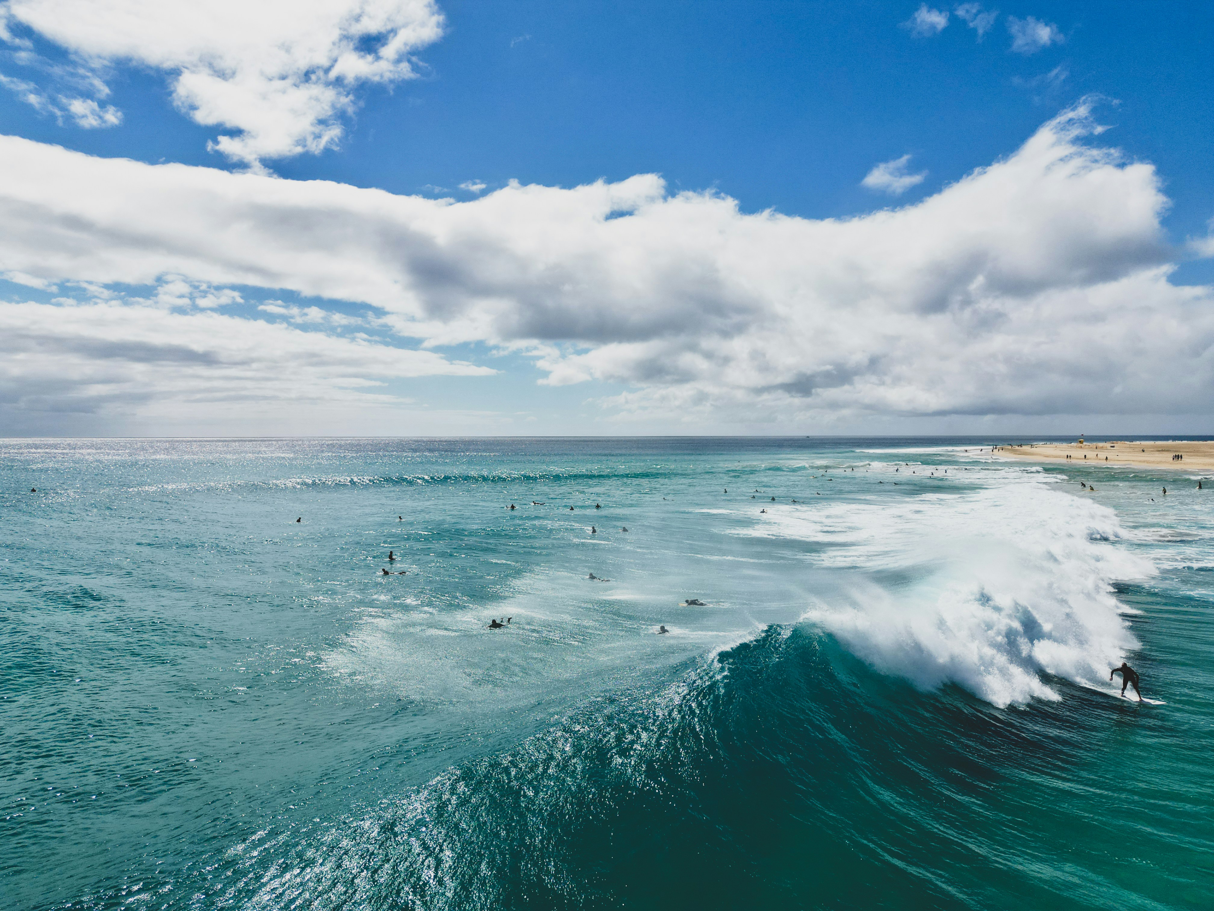 a group of surfers riding a wave in the ocean