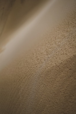 Close-up of a sand-colored textured surface with subtle light gradients.