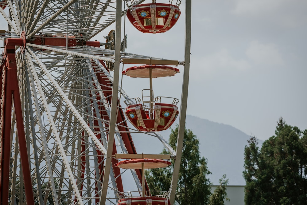 a red and white ferris wheel on a cloudy day