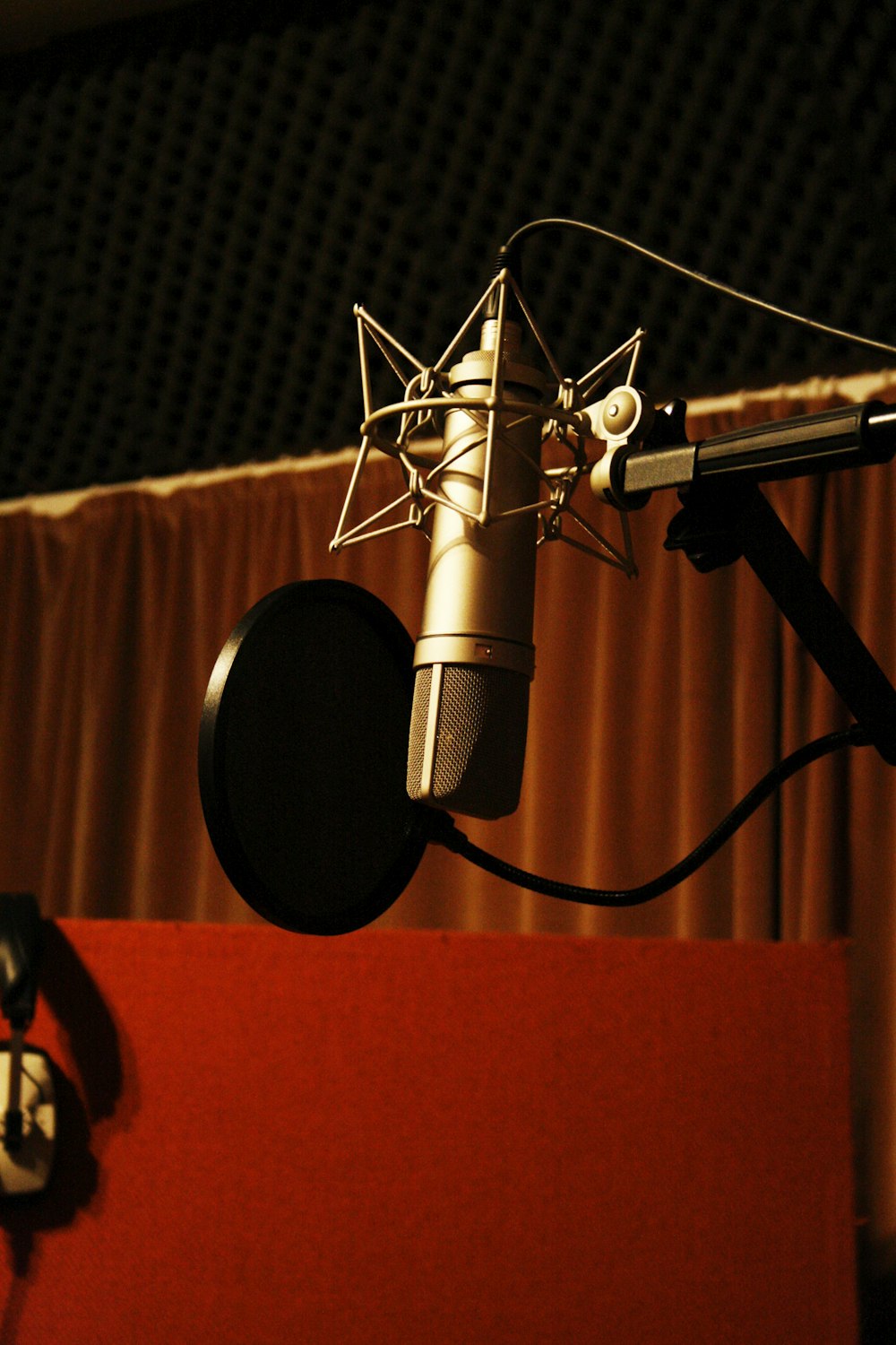 a microphone with a red curtain behind it