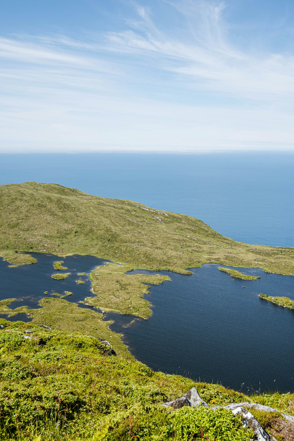 a large body of water surrounded by a lush green hillside