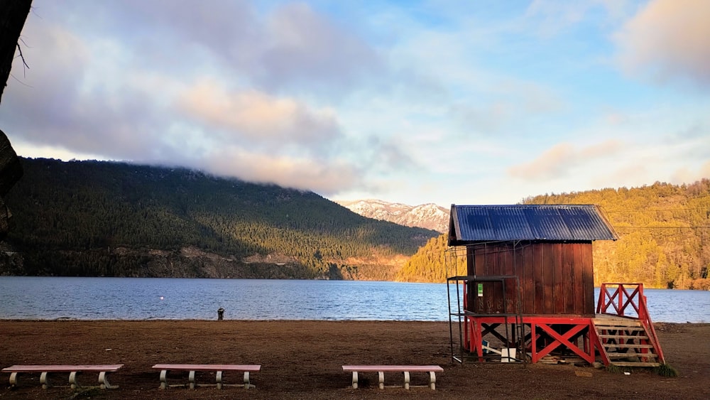 a lifeguard stand next to a lake with mountains in the background