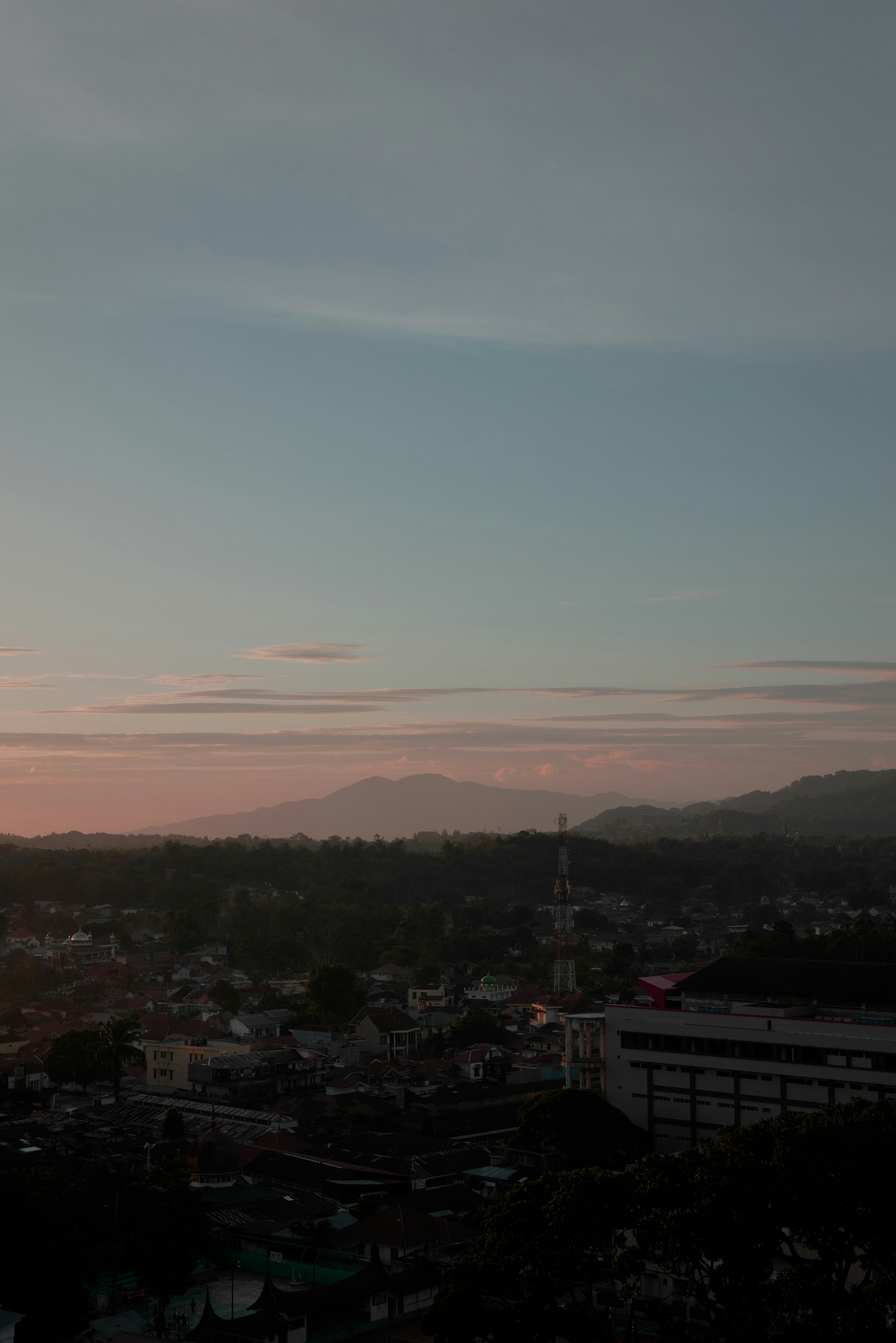 a view of a city at sunset from a hill