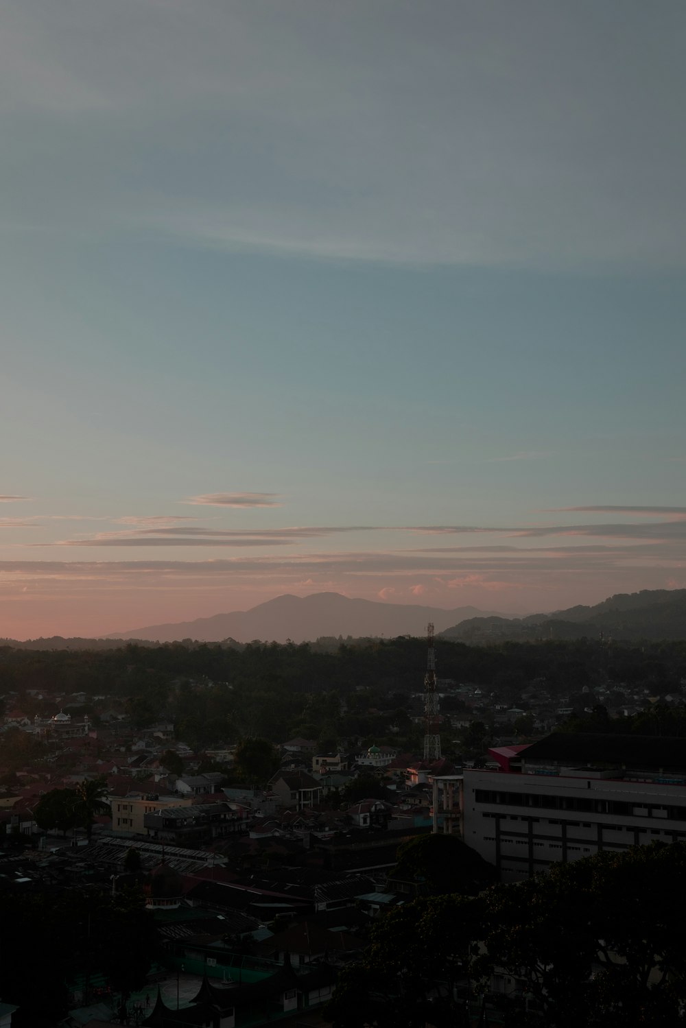 a view of a city at sunset from a hill