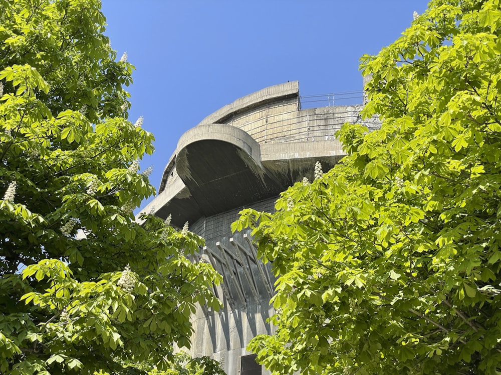 a tall building surrounded by trees and a blue sky